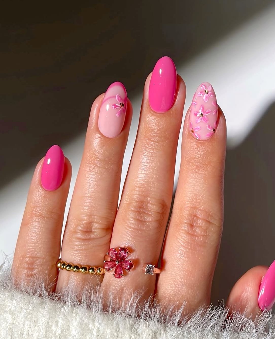 Vibrant pink manicure featuring floral accents