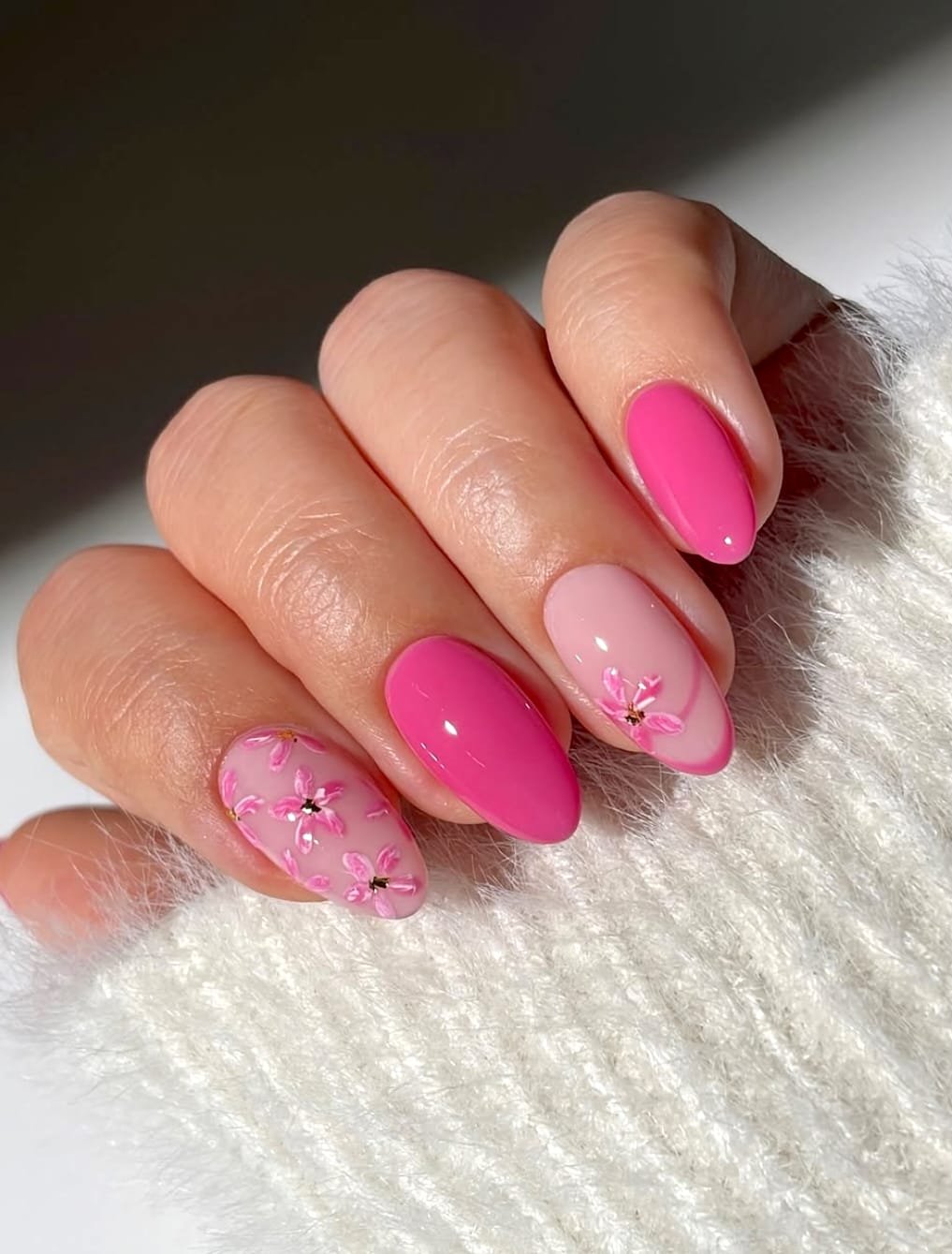 Vibrant pink manicure featuring floral accents