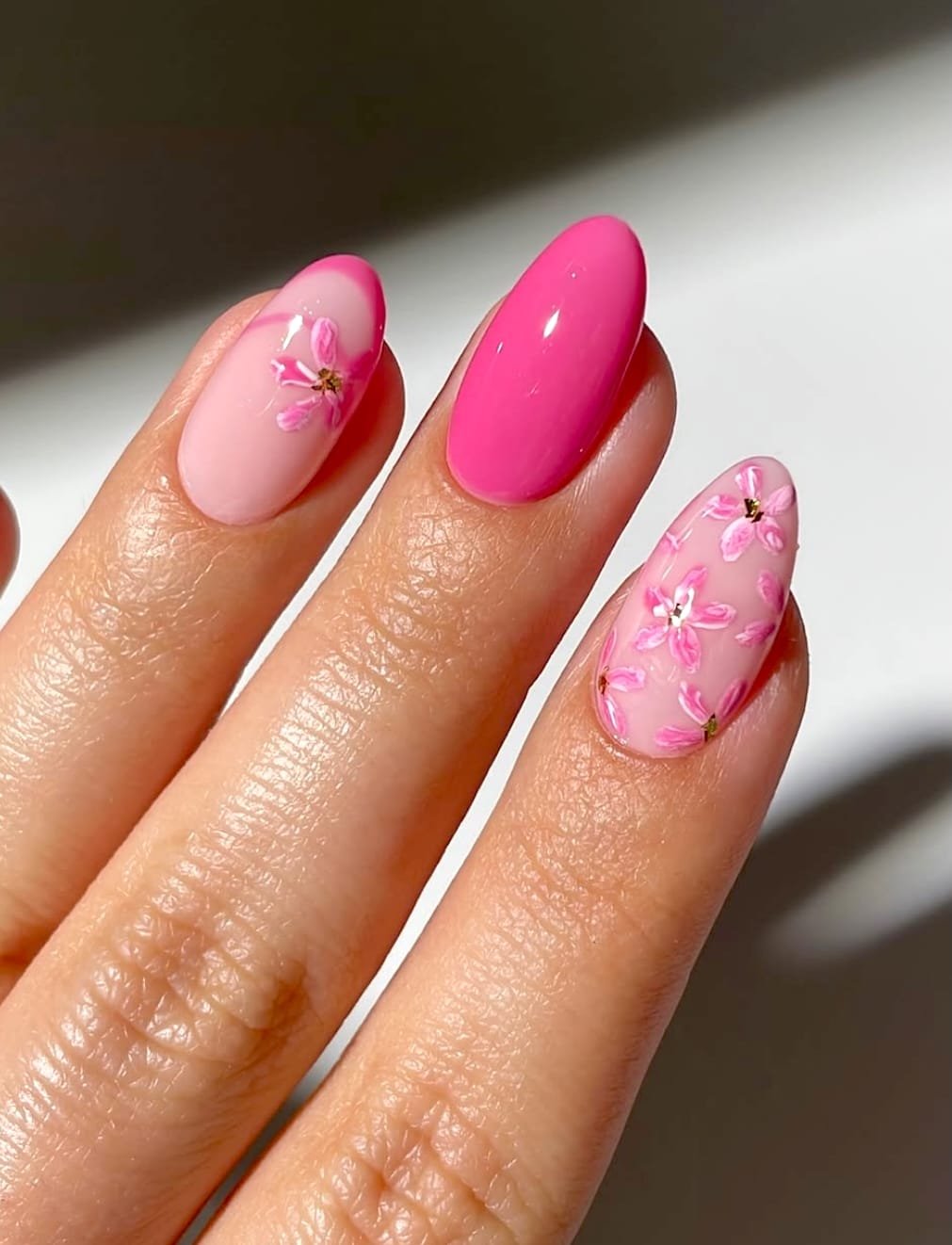 Vibrant pink manicure featuring floral accents