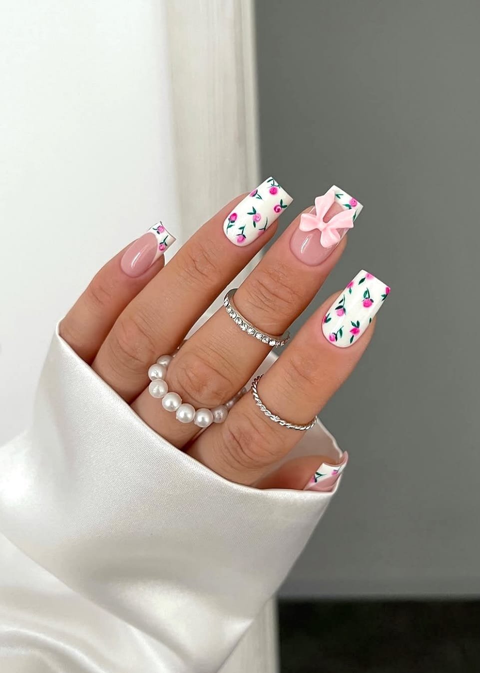Square nails with white, floral, and bow designs